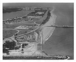 Aerial view of oceanfront green spaces and buildings in the back, looking north