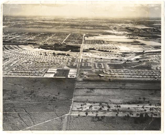 Aerial view of North Miami Beach shopping center and Hallandale Beach Blvd, 1957 - Photograph, recto: [Aerial view of North Miami Beach shopping center. Lower right hand corner shows cleared area which is now covered with about 500 houses. Running from left to right, near the center of the picture, and forming the North boundary of Lake Forest, is Hallandale Beach Blvd, which is a main artery, running from the ocean to Collins Ave., U.S. 1 (W. Dixie Hwy) Road 9, super highway, Road 7 (US 441) and the Sunshine State Turnpike]