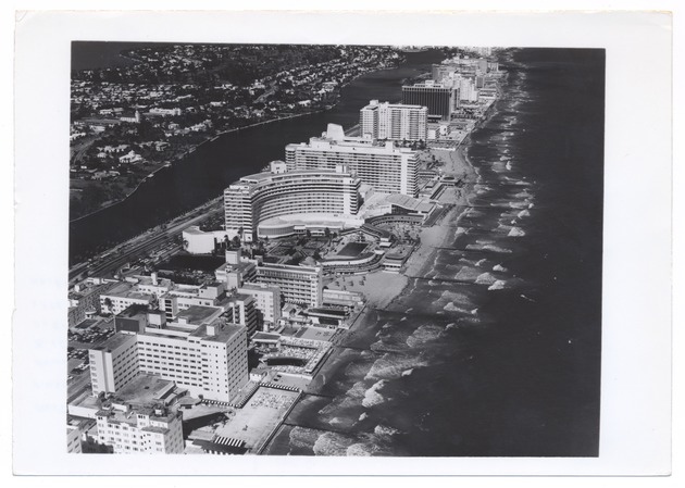 Aerial views of Miami Beach and surrounding islands, 1960-1970 - Photograph, recto: [Aerial view of Miami Beach, Collins Avenue, and Indian Creek facing north]