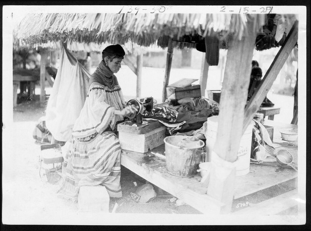 Seminole Indian patchwork, 1921-1927 - 1. Woman with hand-cranked sewing machine, Musa Isle, February 15, 1927. no. 139-30.