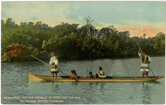 Seminole Indian family in dug-out canoe on Miami River, Florida." - Front