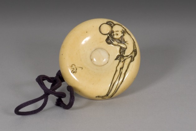 Manju netsuke: Ashinaga beating a drum - artifact front view
