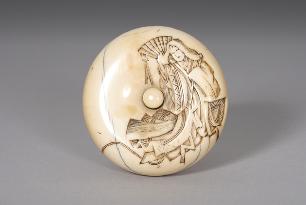 Manju netsuke: Courtesan holding a fan - artifact front view