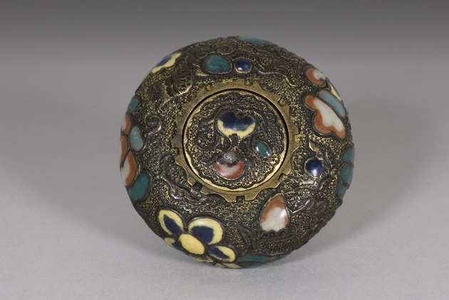 Metal manju netsuke with flowers - artifact front view
