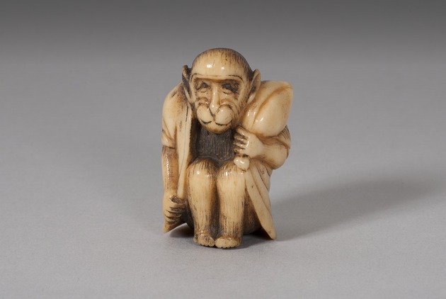 Netsuke: seated monkey holding a peach - artifact front view