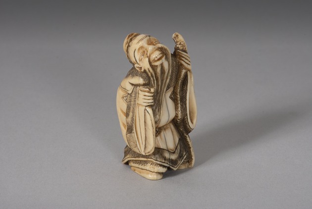 Netsuke: Kazan figure holding a fan and staff - artifact front view