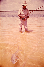 Islamorada Fishing Guide George Hommell Standing in Knee-Deep Water with Hooked Bonefish