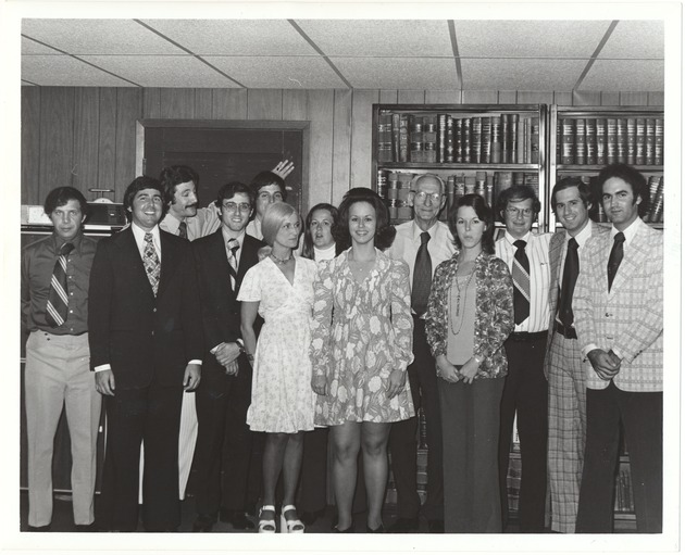 Honorable Joseph Arnold's birthday, 1970s - Photograph, recto: [View of group of office staff surrounding Honorable Joseph Arnold, 1970s]