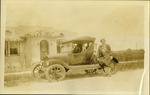 Women sitting on car in front of house