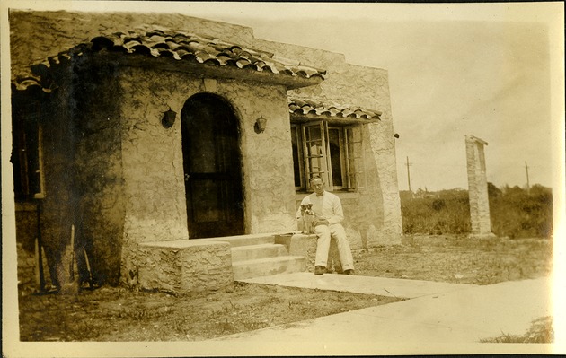Young man and dog outside of house