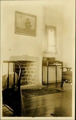 Interior view - fireplace, chair and desk inside home, painting of ship on wall
