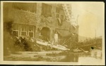 Home - Woman standing on plank near house, ruin from hurricane damage