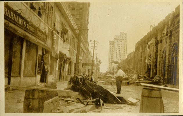 NE 1st Street looking East - Man standing next to damaged car and hurricane debris