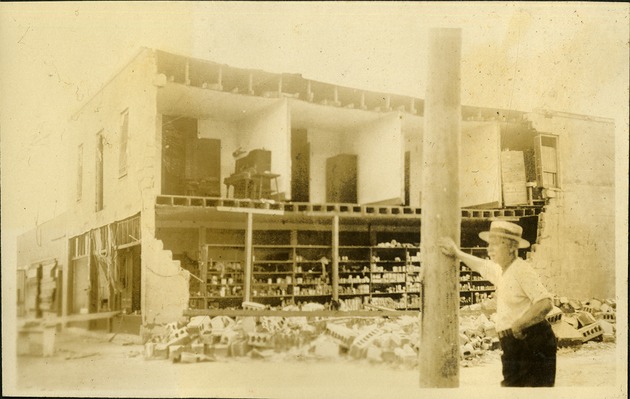 Store at Hallendale. Half of store missing, man standng against pole