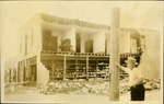 Store at Hallendale. Half of store missing, man standng against pole