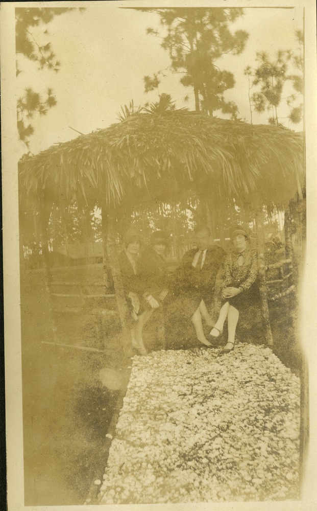 Group of three women and one man sitting in gazebo