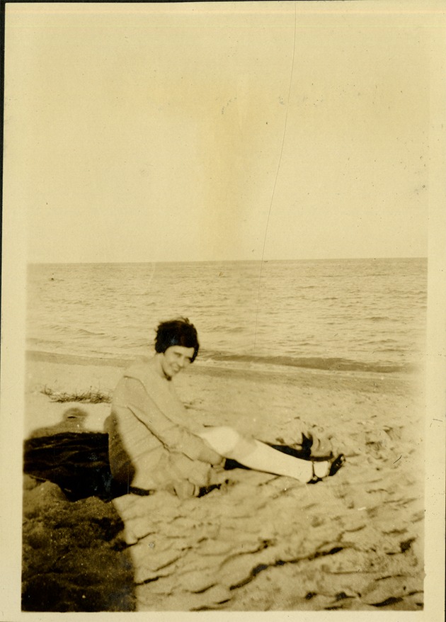 Ashton + B.W. -The Catch - Woman sitting on sand smiling at camera