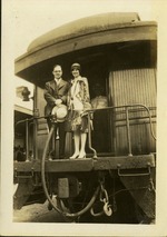Man and woman standing at back of train