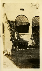 Woman and dog in front of house