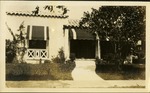 Home with grass, trees and awning