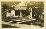View of house from outside, grass, tree, awnings on windows