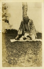 Woman with puppies on blanket in grass
