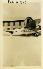 [1929-02-02] Pan American Airways plane with man beside it near hangar