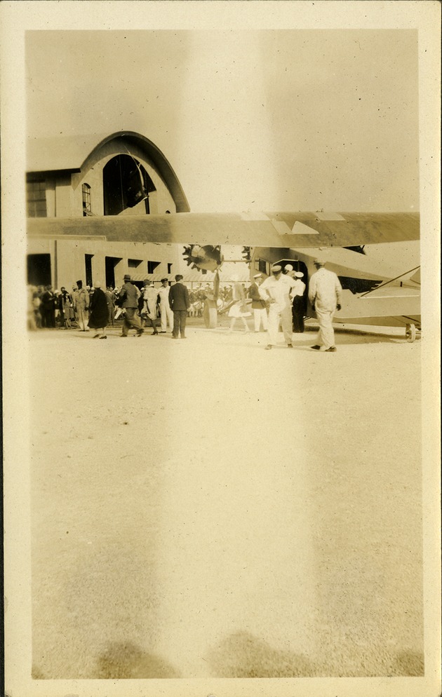 People standing next to plane on airstrip