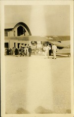People standing next to plane on airstrip