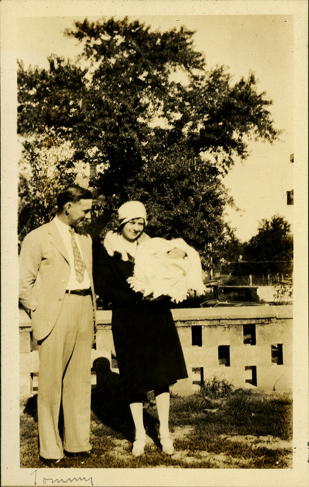 Tommy - Woman holding baby Tommy, man next to her smiling down at child