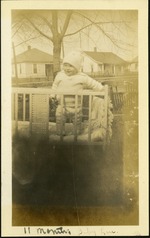 11 months Baby Lou - Baby in hat standing in crib outside