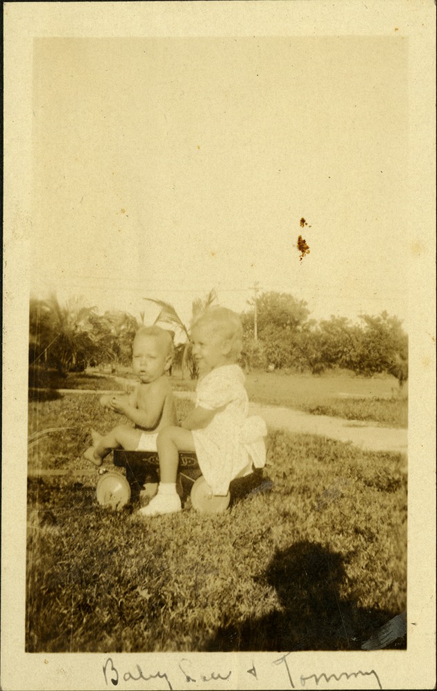 Baby Lou and Tommy - Two small children sitting in wagon in grass