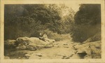 [1923] Two women sitting on rock near river