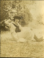 Woman in hat and scarf posing in grass