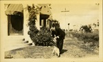 Man with dog on leash in front of house