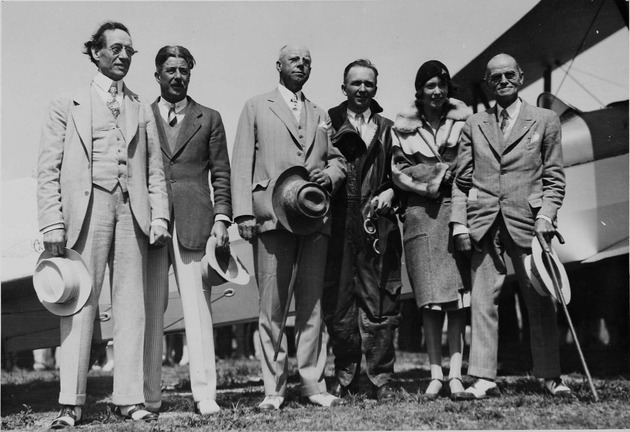 Edward E. "Doc" Dammers and group standing in front of plane