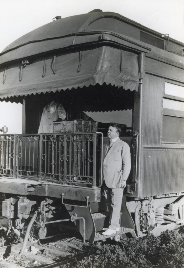 Lee T. Cooper posing with his private railroad car - 
