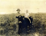 [1930/1935] M.A. Weaver, with son riding a cow, c. 1930