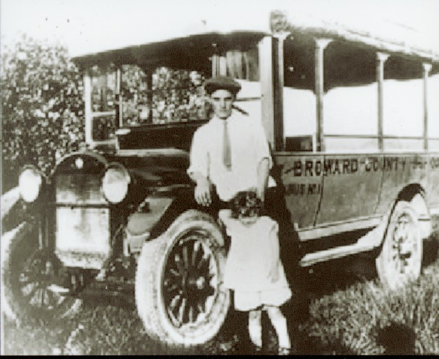 Father and daughter stand by Broward County School Bus