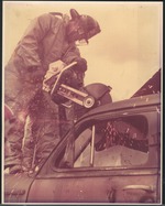 Color photo of firemen using electric saw