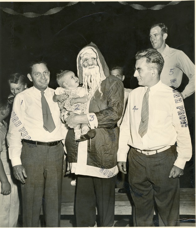 Lions club members with Santa Claus holding a baby