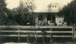 [1925/1927] Woman sitting on steps of house, c. 1925