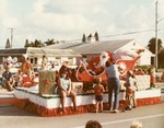 Santa greets children from a parade float, c. 1982