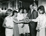 Handing out money, c. 1960