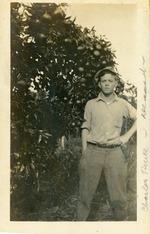 Charles Pence in front of orange tree, c. 1915