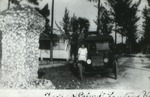 Victoria Dahlberg by old car, c. 1925