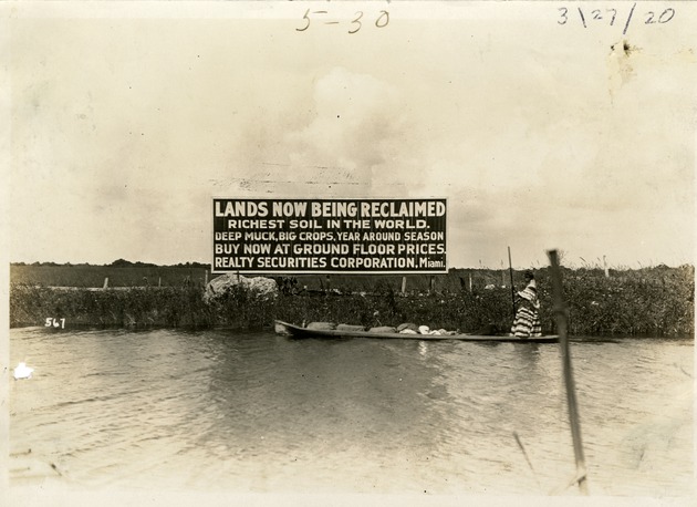 Seminole Woman Poling Past Sign