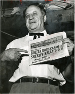 [1955] Reubin Clein pointing to front page coverage of the Bolita Boys
