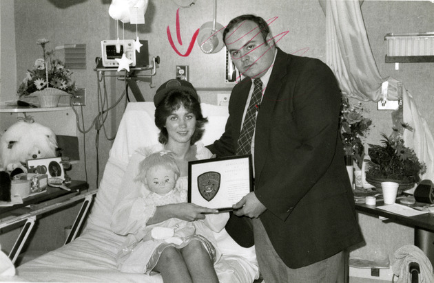 Young woman receiving Certificate of Appreciation in Hospital