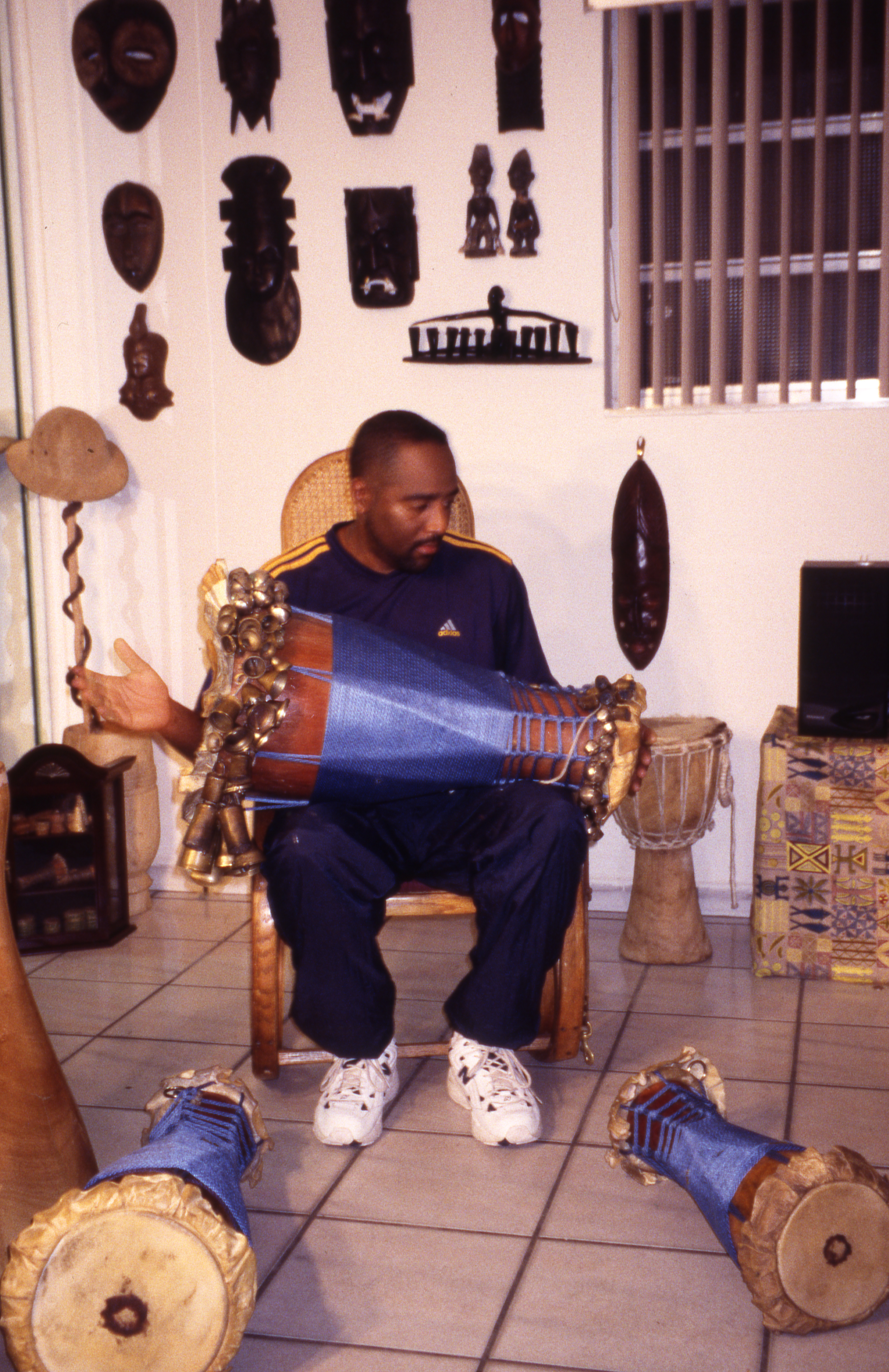 Ezequiel Torres sitting and playing Batá drums